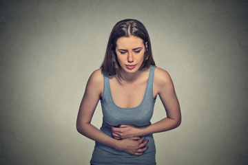 Woman holding stomach in pain for IBS