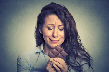 Woman holding chocolate looking stressed