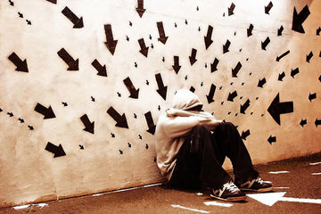 Anxious person leaning against wall