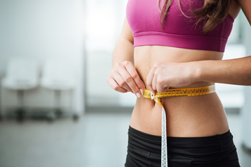 Woman measuring waist with tape